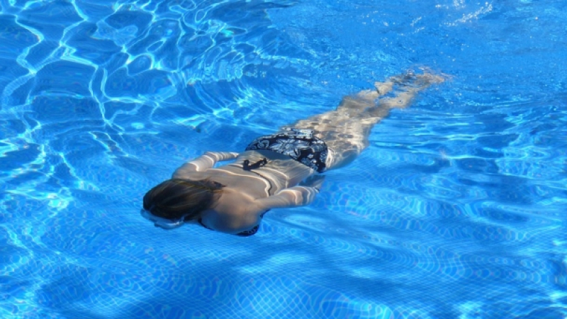 Девица в откровенном купальнике у бассейна